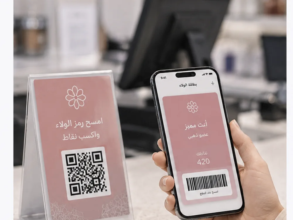 ستاند QR عند الكاشير وعميل يمسح رمز التسجيل من الجوال